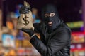 Happy robber is showing stolen bag full of money at night Royalty Free Stock Photo