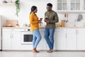 Happy Romantic African American Couple Drinking Wine And Chatting Together In Kitchen