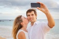 Happy romantic couple on the beach taking photo Royalty Free Stock Photo