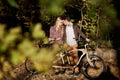 Romantic couple, man and attractive girl close together at tandem bicycle in dark autumn park. Royalty Free Stock Photo