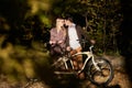 Romantic couple, man and attractive girl close together at tandem bicycle in dark autumn park. Royalty Free Stock Photo