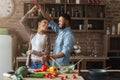 Happy romantic couple dancing in kitchen while cooking