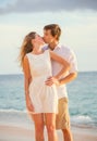 Happy romantic couple kissing on the beach at sunset Royalty Free Stock Photo