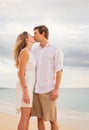 Happy romantic couple kissing on the beach at sunset Royalty Free Stock Photo