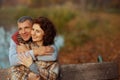 happy romantic couple in park embracing while sitting on bench Royalty Free Stock Photo