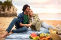 Happy romantic couple relaxing together on outdoor picnic at beach Royalty Free Stock Photo