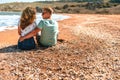 Happy romantic couple woman and man sitting on the beach near the sea and hug each other Royalty Free Stock Photo