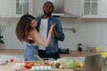 Happy interracial couple dancing in the kitchen. African-American man and woman having fun in the kitchen Royalty Free Stock Photo