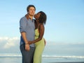 Happy and romantic mixed race couple with attractive black African American woman and Caucasian man playing on beach having fun Royalty Free Stock Photo