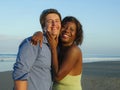 Happy and romantic mixed race couple with attractive black African American woman and Caucasian man playing on beach having fun Royalty Free Stock Photo