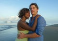 Happy and romantic mixed race couple with attractive black African American woman and Caucasian man playing on beach having fun Royalty Free Stock Photo