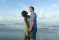 Happy and romantic mixed race couple with attractive black African American woman and Caucasian man playing on beach having fun Royalty Free Stock Photo