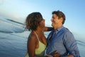 Happy and romantic mixed race couple with attractive black African American woman and Caucasian man playing on beach having fun Royalty Free Stock Photo