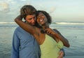 Happy and romantic mixed race couple with attractive black African American woman and Caucasian man playing on beach having fun Royalty Free Stock Photo