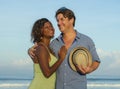 Happy and romantic mixed race couple with attractive black afro American woman and white man playing on beach having fun enjoying Royalty Free Stock Photo