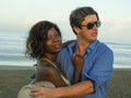 Happy and romantic mixed race couple with attractive black afro American woman and white man playing on beach having fun enjoying Royalty Free Stock Photo