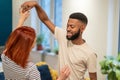 Happy romantic multiracial young couple in love learning to dance together at home Royalty Free Stock Photo