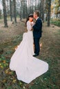 Happy romantic newly married couple embracing each other holding a candle in the autumn pine forest Royalty Free Stock Photo