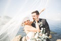 Happy and romantic scene of just married young wedding couple posing on beautiful beach