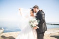 Happy and romantic scene of just married young wedding couple posing on beautiful beach Royalty Free Stock Photo