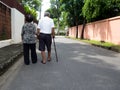 Happy romantic senior asian couple walking and holding hands on the road at the village. Concept of senior couple and take care of