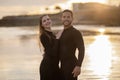 Happy Romantic Young Couple In Wetsuits Embracing On Beach At Sunset Time Royalty Free Stock Photo