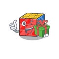 Happy rubic cube character having a gift box