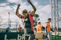 Happy runner raising arms after finish a extreme obstacle race