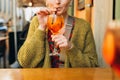 Happy 30s girl sitting on the cafe terrace on the city street. Traveler. Woman hands toasting with aperol spritz Royalty Free Stock Photo