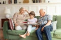 Happy 60s grandmother and grandfather read book with cute small granddaughter. Royalty Free Stock Photo