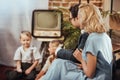 happy 1950s style parents sitting on sofa and lookign at cute little children Royalty Free Stock Photo