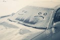 Happy and sad smiley emoticon face in snow on car windows, winter season joy and happiness concept Royalty Free Stock Photo