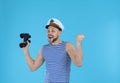Happy sailor with binoculars on light blue background Royalty Free Stock Photo