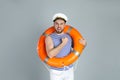 Happy sailor with ring buoy on grey background