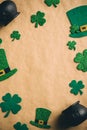 Happy Saint Patrick\'s Day concept. Flat lay green hats shamrock clover leaves pots of gold on kraft paper background