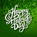 Happy Saint Patrick's day handwritten message, brush pen lettering on green shamrock background