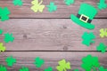 Happy Saint Patrick`s of handmade paper clover leaves and hat on grey wooden background