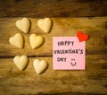 Happy Saint valentines day with post it note and heart shaped chocolate frame on wooden table Royalty Free Stock Photo