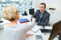 happy sales representative gives handshake to female customer