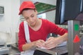 Happy saleswoman writing note at counter in butchers shop