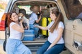 Happy same-sex family going on a car trip around the country. Lesbian couple with son and dog are loading luggage in the Royalty Free Stock Photo