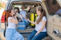 Happy same-sex family going on a car trip around the country. Lesbian couple with son and dog are loading luggage in the Royalty Free Stock Photo
