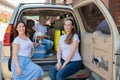 Happy same-sex family going on a car trip around the country. Lesbian couple with son and dog are loading luggage in the Royalty Free Stock Photo