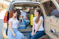 Happy same-sex family going on a car trip around the country. Lesbian couple with son and dog are loading luggage in the Royalty Free Stock Photo