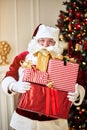 Happy Santa Claus brought many giftboxes to children. New year and Merry Christmas holidays concept