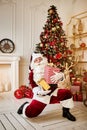 Happy Santa Claus brought many giftboxes to children. New year and Merry Christmas holidays concept