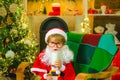 Santa Claus child eating a cookie and drinking glass of milk at home. Santa child boy picking cookie. Greeting card for Royalty Free Stock Photo