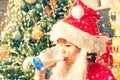 Happy santa claus eating a cookie and drinking glass of milk at home. Merry Christmas. Kid Santa Claus enjoying in Royalty Free Stock Photo