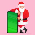 Happy Santa Claus with glasses is standing next to a large smartphone with a chroma key. Cartoon Santa points to the mobile phone