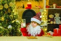 Happy Santa Claus helper with glass of milk and cookie. Little Santa picking cookie and glass of milk at home.